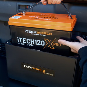 A person lifts a GoFurther Premium Battery Box with iTECHDCDC25 & iTECHBM500 from a black iTechworld case inside a vehicle, providing an ideal off-grid power solution.