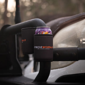 A purple soda can is held in an iTechworld Magnetic Stubby Holder (375mL), attached to a vehicle’s metal frame with outdoor scenery blurred in the background.