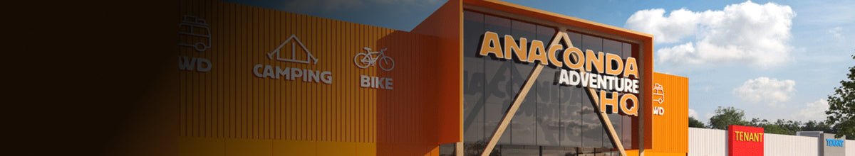 The front of an Anaconda Adventure HQ store with bold orange and yellow signage, blue sky, and clouds in the background. Icons for 4WD, Camping, and Bike are visible on the building.