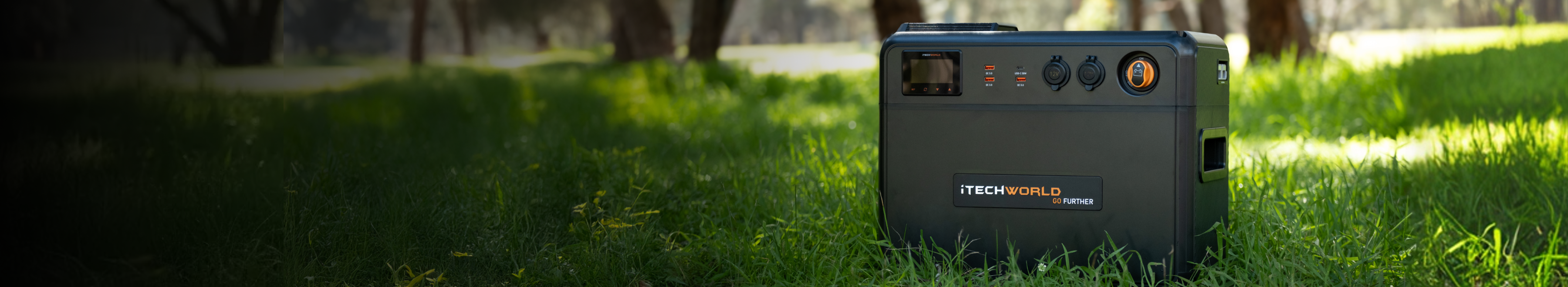 An orange and black portable power station sits on a wooden surface outdoors, surrounded by a forest with tall, blurred trees in the background.