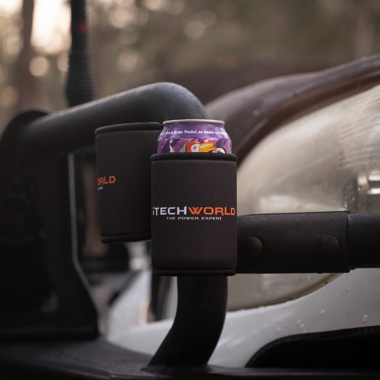 A purple soda can is held in an iTechworld Magnetic Stubby Holder (375mL), attached to a vehicle’s metal frame with outdoor scenery blurred in the background.