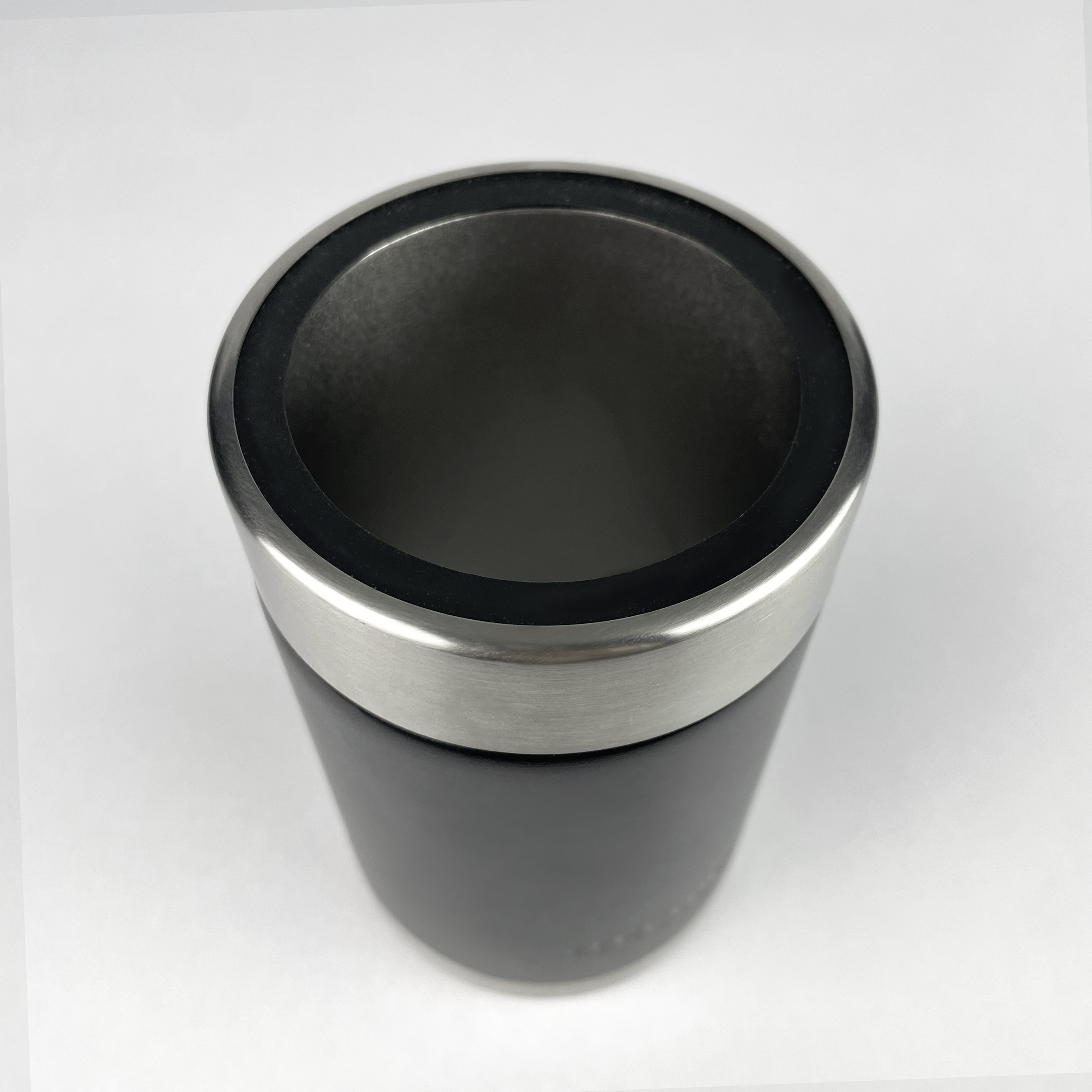 A black and silver iTechworld 375mL Can Cooler is displayed from above on a white background; its insulated stainless steel design keeps drinks cold and features a smooth, modern look.