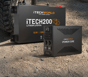 Two black iTechworld devices, the Mini Power Core and Super Slim 200Ah, are placed on dirt beside a vehicle tire, lit by sunlight.