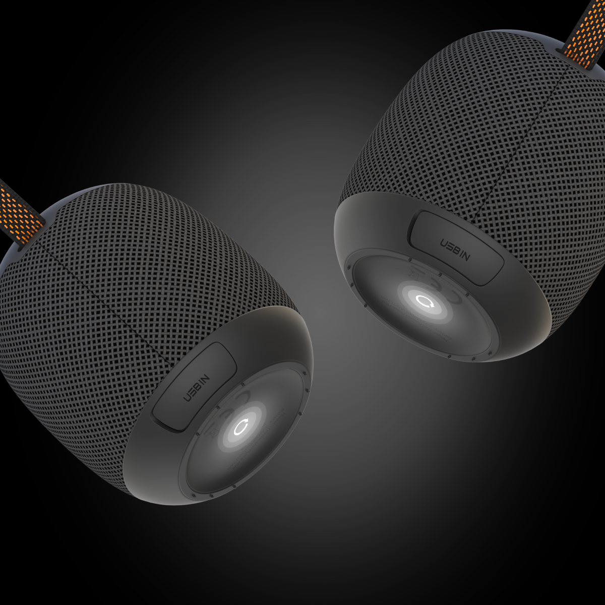 Two iTechworld Pulse Mini waterproof portable speakers, black and cylindrical with mesh exteriors, hang against a dark gradient backdrop. Each features a USB-IN port, power button at the base, and a fabric cord for easy portability.