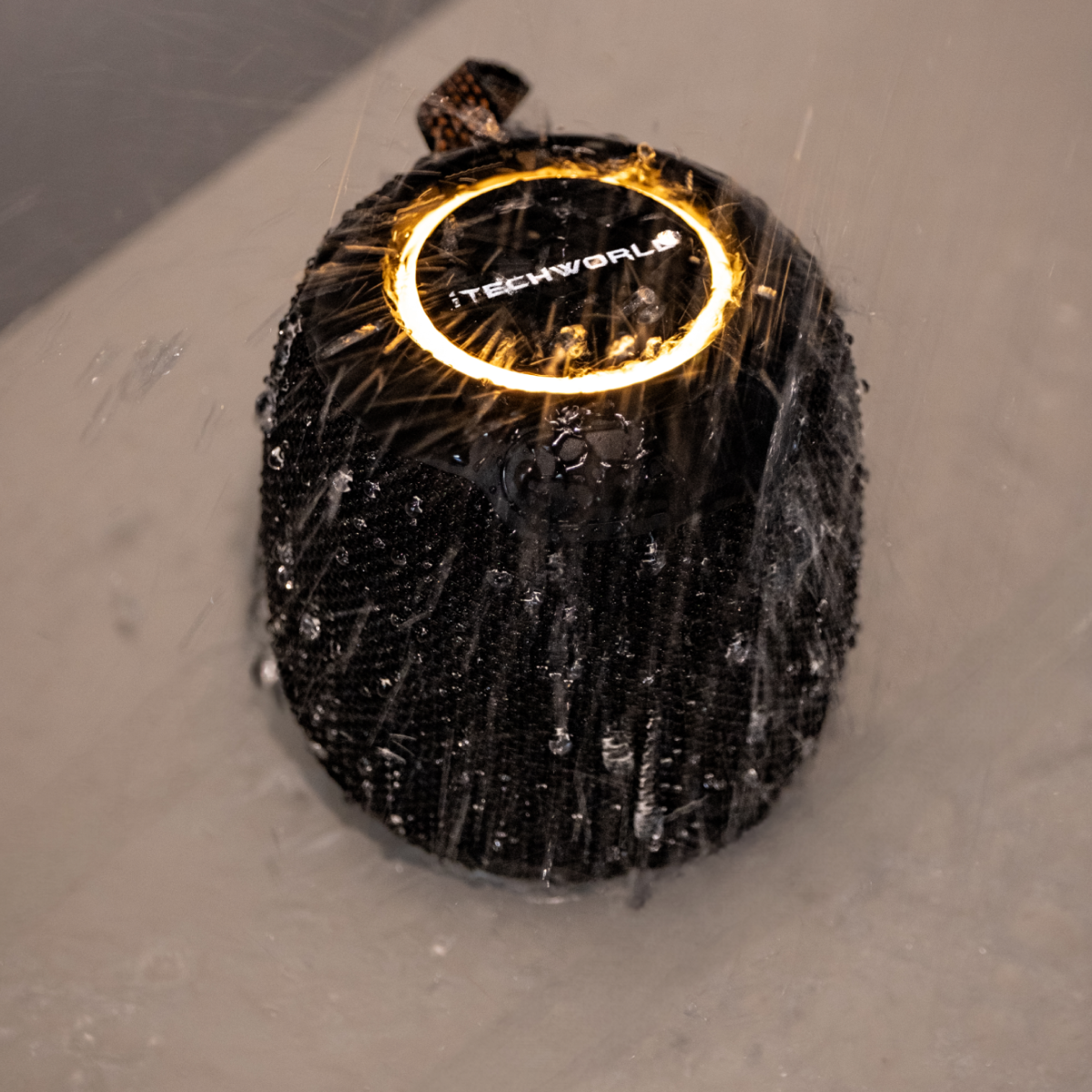 The iTechworld Pulse Mini Waterproof Portable Speaker, shown with a glowing ring light and water splashes, highlights its water-resistant design and high-fidelity audio.