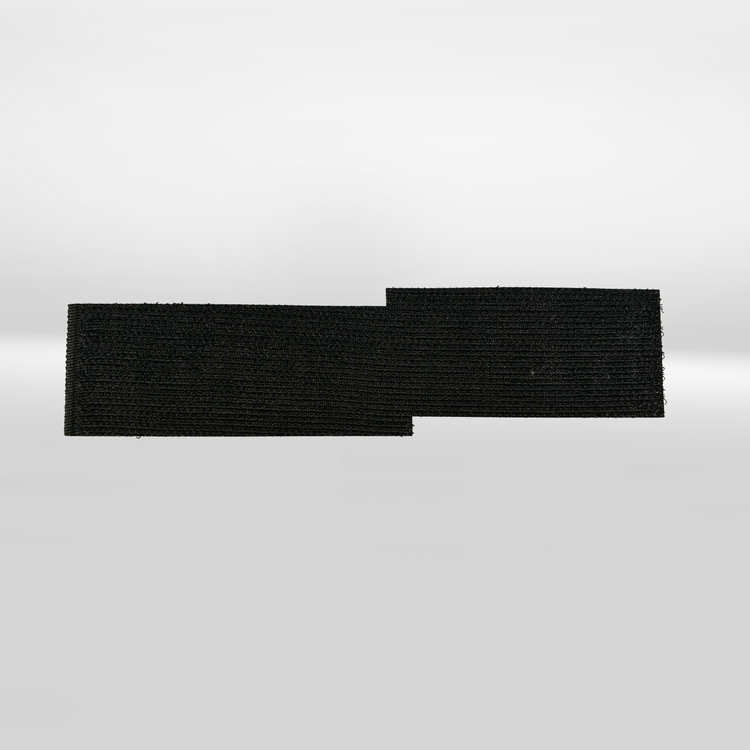 An iTechworld Velcro Patch, a rectangular black hook-and-loop fastener from iTechworld, lies on a plain white surface with a small section extending out on the right side.