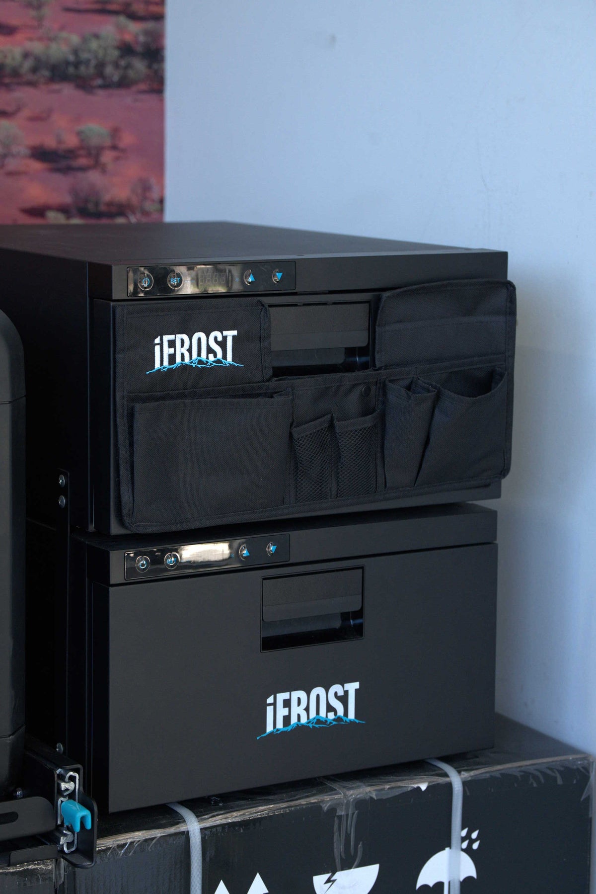 A close-up of a black metal utility cabinet or tool box with the brand name 'iFROST' printed in white on the front, next to a matching black tool bag with the same logo.
