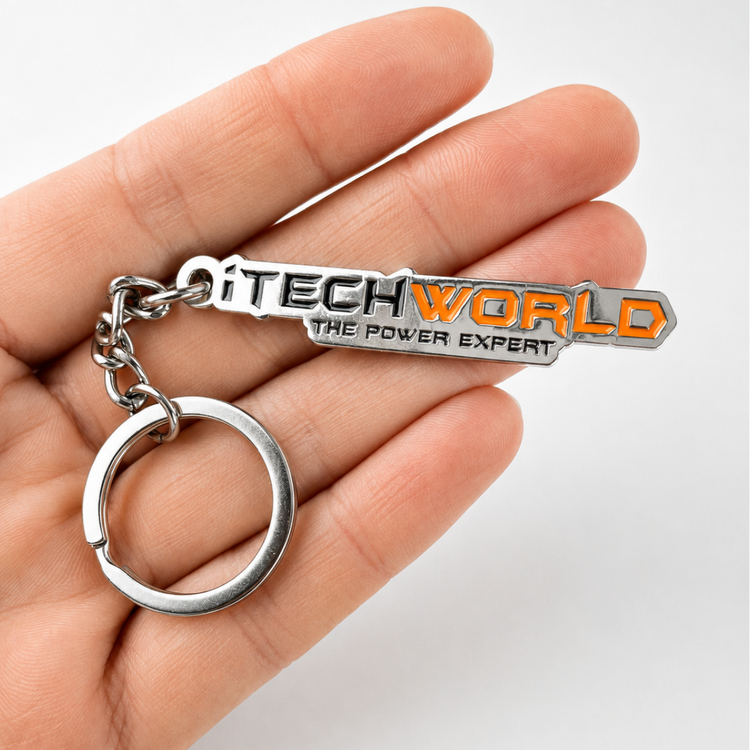 A hand holds an iTechworld iron keyring with laser-etched branding in black and orange, attached to a silver keyring.
